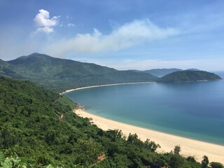 Fototapeta premium Heaven on earth, a sandy, yellow beach alongside a hill covered in rainforest