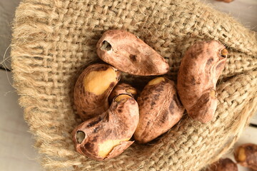 Fragrant fried salted cashews on a jute fabric, close-up.