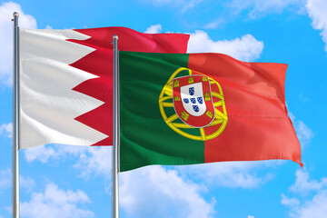 Portugal and Bahrain national flag waving in the windy deep blue sky. Diplomacy and international relations concept.
