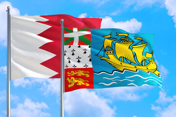 Saint Pierre And Miquelon and Bahrain national flag waving in the windy deep blue sky. Diplomacy...