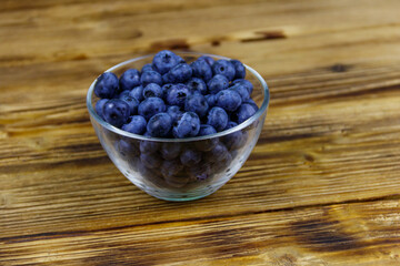 Fresh blueberry in glass bowl on a wooden table