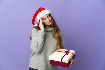 Girl with christmas hat holding a present isolated on white background with headache