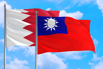 Taiwan and Bahrain national flag waving in the windy deep blue sky. Diplomacy and international relations concept.