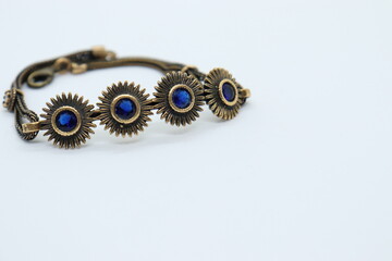 
bronze bracelet with blue crystals, white background