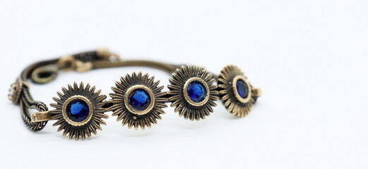 
bronze bracelet with blue crystals, white background