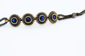 
bronze bracelet with blue crystals, white background