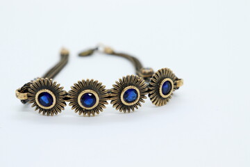 
bronze bracelet with blue crystals, white background