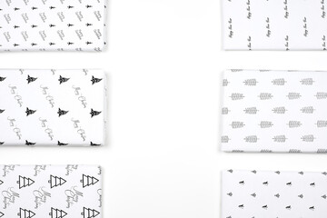 Xmas present wrapped in paper with festive prints. Christmas gift on white background. Homemade bright Christmas present box