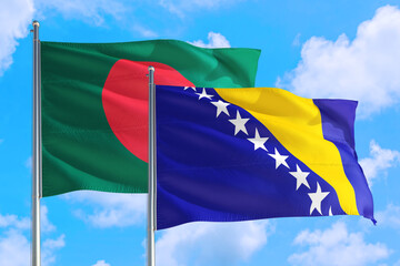 Bosnia Herzegovina and Bangladesh national flag waving in the windy deep blue sky. Diplomacy and international relations concept.