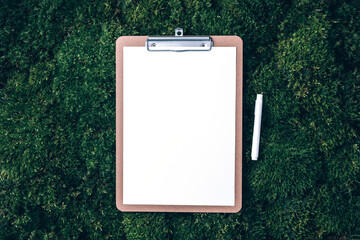 Notepad, pencil on green grass, moss background. Copy space. Top view. Office mock up, remote job. Wild nature, ecology concept. Summer forest. Sustainable, organic, zero waste lifestyle