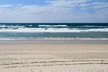 Fototapeta na wymiar Sand beach and turquoise sea on the Gold Coast in Queensland, Australia