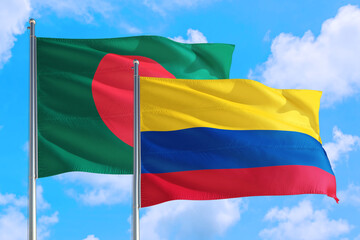 Colombia and Bangladesh national flag waving in the windy deep blue sky. Diplomacy and international relations concept.
