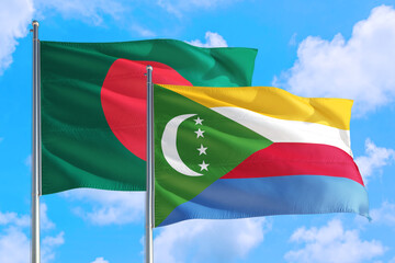 Comoros and Bangladesh national flag waving in the windy deep blue sky. Diplomacy and international...