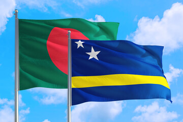 Curacao and Bangladesh national flag waving in the windy deep blue sky. Diplomacy and international relations concept.