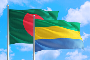 Gabon and Bangladesh national flag waving in the windy deep blue sky. Diplomacy and international relations concept.