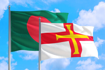 Guernsey and Bangladesh national flag waving in the windy deep blue sky. Diplomacy and international relations concept.