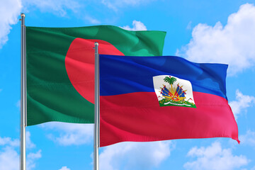 Haiti and Bangladesh national flag waving in the windy deep blue sky. Diplomacy and international relations concept.