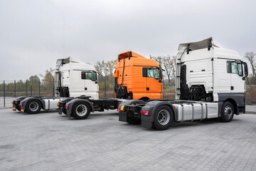 A new fleet of trucks is in the parking lot. Parking lot with trucks for delivery, transportation, transportation of goods and vehicle concept.