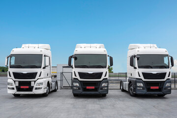 Naklejka premium The trucks are parked in a row. Freight road transport, logistics and transport concept. Parking lot with trucks for delivery