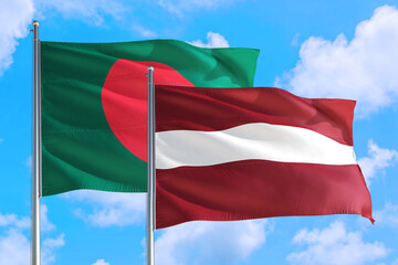 Latvia and Bangladesh national flag waving in the windy deep blue sky. Diplomacy and international relations concept.
