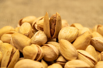 Salted pistachios lie on the burlap. Close up.