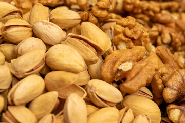 Pistachios and walnuts lie on the sacking. Close up.
