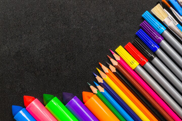 Frame from pencils and felt-tip pens on chalk background. Back to school and new academic year concept. Copy space, place for text.