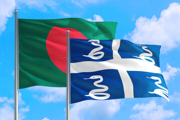 Martinique and Bangladesh national flag waving in the windy deep blue sky. Diplomacy and international relations concept.