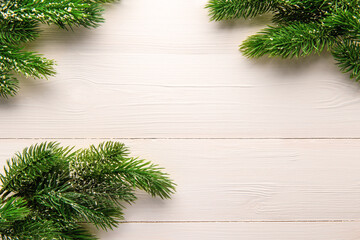 Christmas tree branches on a light wooden background. New year and Christmas background. Space for text