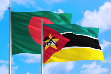 Mozambique and Bangladesh national flag waving in the windy deep blue sky. Diplomacy and international relations concept.