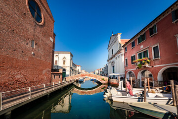 Fototapeta na wymiar Romantic cityscape of Ghioggia - near Venice - with canals, buidings, bridges and canals in Daylight. Bridge Filippini