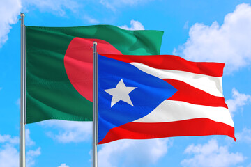 Puerto Rico and Bangladesh national flag waving in the windy deep blue sky. Diplomacy and international relations concept.