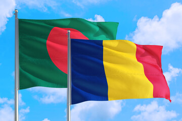 Romania and Bangladesh national flag waving in the windy deep blue sky. Diplomacy and international relations concept.