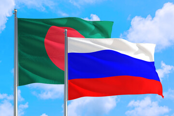 Russia and Bangladesh national flag waving in the windy deep blue sky. Diplomacy and international relations concept.