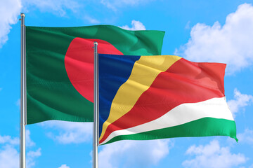 Seychelles and Bangladesh national flag waving in the windy deep blue sky. Diplomacy and international relations concept.