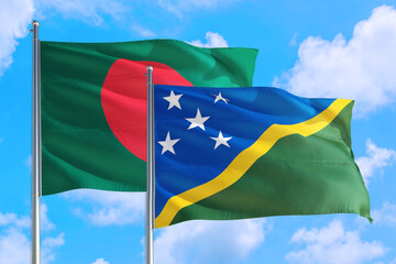 Solomon Islands and Bangladesh national flag waving in the windy deep blue sky. Diplomacy and...