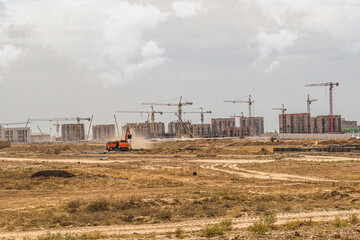 Fototapeta na wymiar Construction of new high-rise modern buildings in the steppe in Kazakhstan.