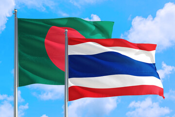 Thailand and Bangladesh national flag waving in the windy deep blue sky. Diplomacy and international relations concept.