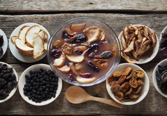 Healthy natural dessert fruit jelly with dried fruits surrounded by dried fruits on plates on a wooden background. Home preparation of dried fruits.