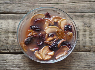 Kissel with dried fruits in a glass plate on a wooden background. Healthy natural homemade dessert. Home preparation of dried fruits.