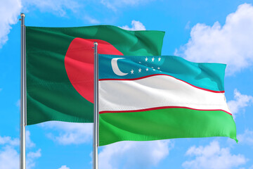 Uzbekistan and Bangladesh national flag waving in the windy deep blue sky. Diplomacy and international relations concept.