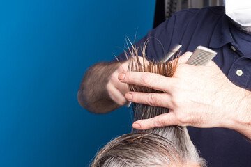 Hairdresser trimming brown hair with scissors