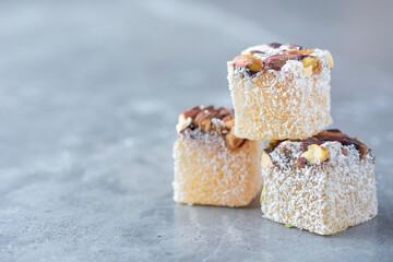 Turkish delight with pistachios on grey background. Copy space. Traditional eastern cuisine. Traditional middle eastern sweets. Jewish, turkish, arabic national dessert. Turkish delight