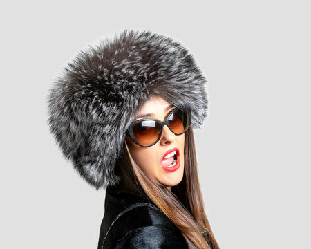 Beautiful Woman In A Fur Hat On A Bright Background. Winter Fashion Background.