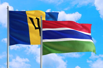 Gambia and Barbados national flag waving in the windy deep blue sky. Diplomacy and international relations concept.