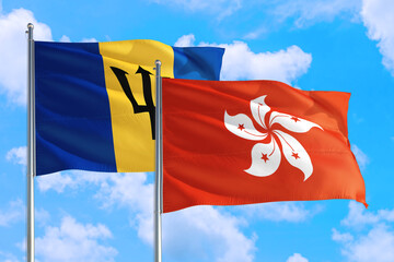 Hong Kong and Barbados national flag waving in the windy deep blue sky. Diplomacy and international relations concept.