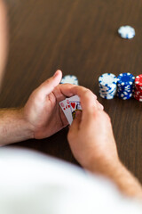 Male playing poker and hiding his cards. 