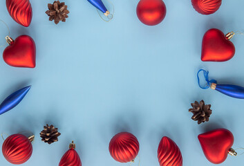 Christmas Happy New Year composition with red hearts, balls, cones. xmas frame on blue background. Greeting card, mock up, flat lay holiday concept, top view, copy space