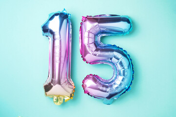 Creative layout. Rainbow foil balloon number, digit fifteen. Birthday greeting card with...