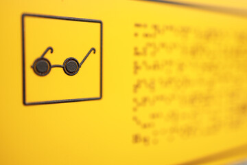 sign for the blind on a yellow background braille alphabet for reading people who do not see